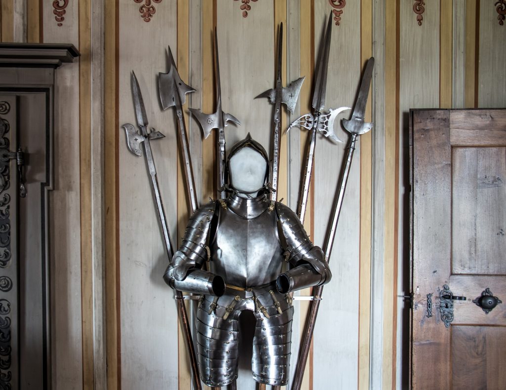 a suit of armour with six pole arms behind it